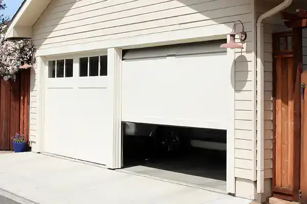 A photo of a garage door that is stuck half open and is in need of emergency garage door services.